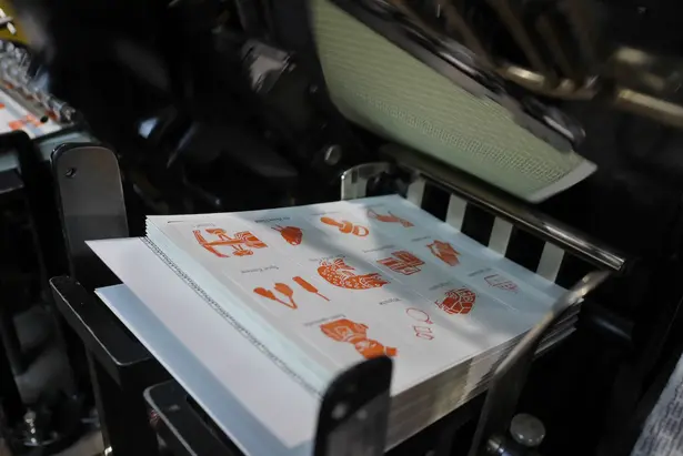 Printed card sheets are die-cut in a machine ©SPEICHER_Leute e.V.